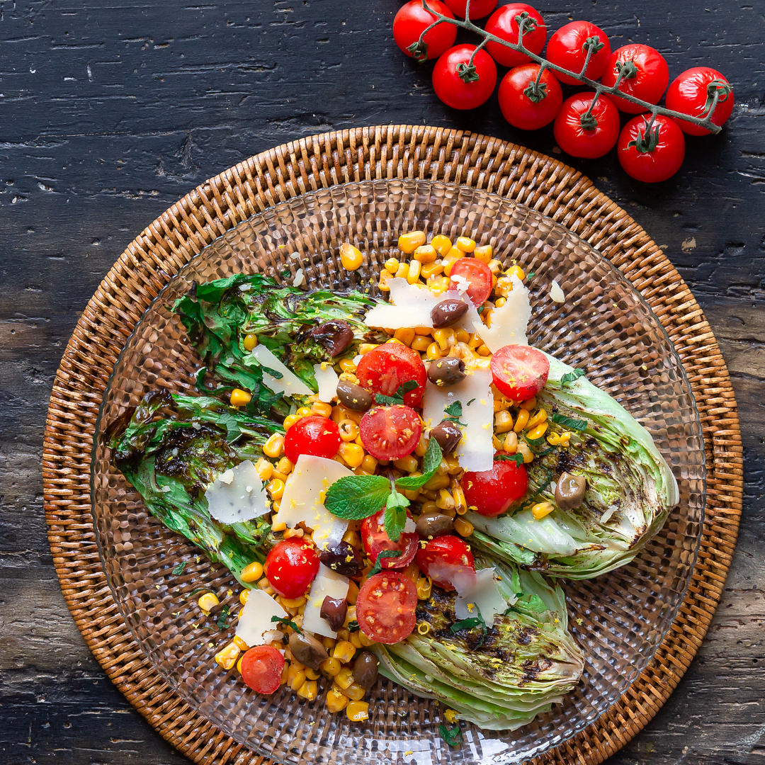 Immagine: Lattuga romana piastrata con insalatina di mais, taggiasche, pachino, pecorino, menta e zest di limone